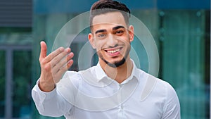 Portrait friendly smiling toothy hispanic arab business man spaniard boss wears white formal shirt showing gesture of