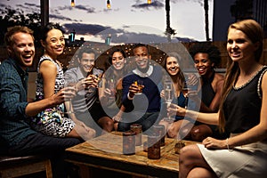 Portrait Of Friends Enjoying Night Out At Rooftop Bar