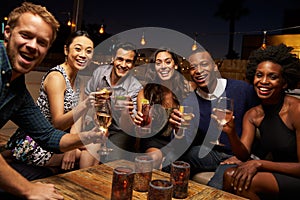 Portrait Of Friends Enjoying Night Out At Rooftop Bar