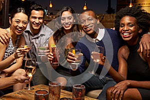 Portrait Of Friends Enjoying Night Out At Rooftop Bar