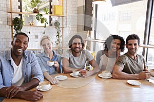 Portrait Of Friends Meeting Around Table In Coffee Shop