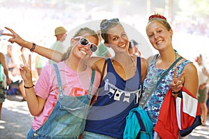 Portrait, friends and peace sign while bonding with smiles at outdoor music festival in Germany. Confident, relaxed and