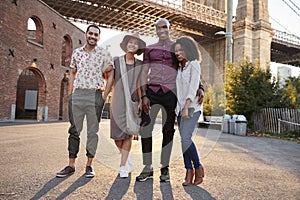 Portrait Of Friends Walking By Brooklyn Bridge In New York City