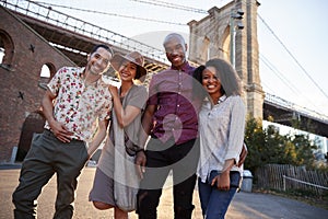 Portrait Of Friends Walking By Brooklyn Bridge In New York City