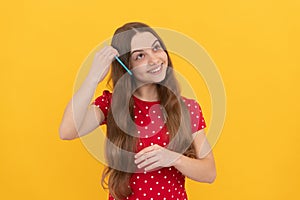 portrait of frizz child. haircare and hair loss. female fashion model. smiling kid combing hair.