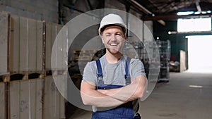 Portrait of a frontline essential worker in a warehouse. In the background big warehouse