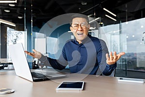 Portrait of frustrated and angry boss inside office, asian man looking at camera and shouting upset, man at workplace