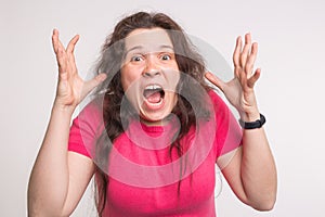 Portrait of a frustrated angry screaming woman screaming out loud on white background