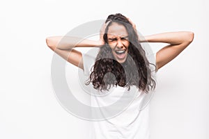 Portrait of a frustrated angry woman screaming out loud and pulling her hair out isolated on the white background