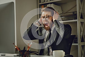 Portrait of a frustrated bearded businessman in eyeglasses screaming