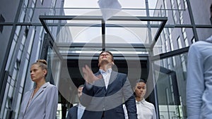 Portrait frustrated businessman standing at office building throwing papers.