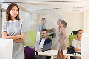 Portrait of frustrated young business woman standing in office