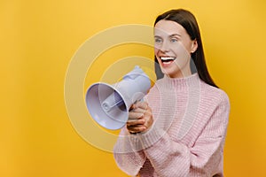 Portrait of fun expressive happy smiling student young woman scream aside shouting in megaphone, dressed in knitted sweater