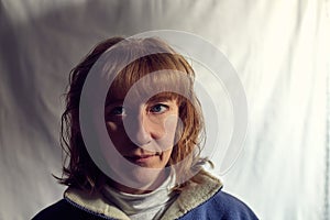 Portrait of fun middle-aged woman on a white background. Unprofessional female model with shy smile awkwardly posing in the Studio