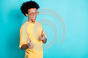 Portrait of funky cool man with afro hairstyle wear oversize t-shirt indicating at you eye blink isolated on teal color