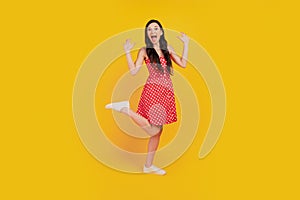 Portrait of funky excited astonished lady scream rejoice wear dotted red mini dress sneakers on yellow background