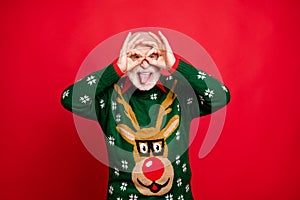 Portrait of funky funny old man grey hair enjoy christmas theme party make binoculars with his fingers imagine he spy