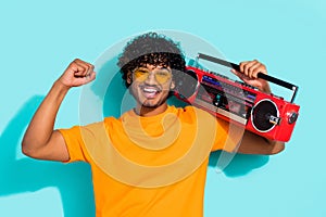 Portrait of funky guy fist up listen vintage boombox summer discotheque chill sunglasses rayban isolated on aquamarine photo