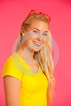 Portrait of a funky young woman in yellow t shirt over pink back