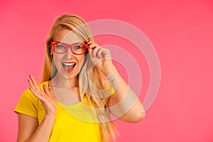 Portrait of a funky young woman in yellow t shirt over pink back