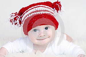 Portrait of funny baby in red knitted hat