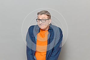Portrait of funny blond mature man with glasses making goofy grimace