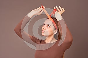 Portrait of a funny blonde with a red pois bow on her head, creating a fun hairstyle