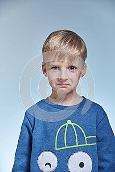 Portrait of funny boy in studio 7 years old, positive scare