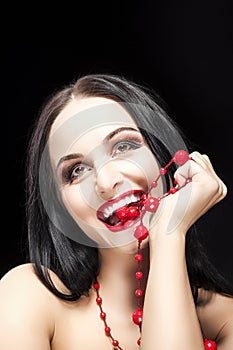 Portrait of Funny Caucasian Brunette Woman Biting Her Long Red Beads