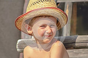 Portrait of funny child boy in straw hat.