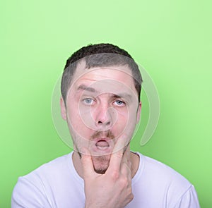 Portrait of funny cluelles man against green background