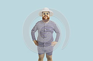 Portrait of funny comic chubby man in summer hat on isolated light blue background.