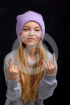 Portrait of funny cool teen girl making Rock Gesture