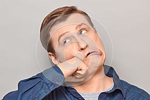 Portrait of funny crazy mature man punching himself in face