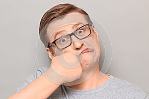 Portrait of funny crazy mature man punching himself in face