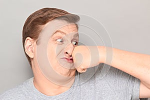 Portrait of funny crazy mature man punching himself in face