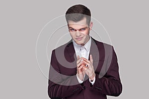Portrait of funny cunning handsome young man in violet suit and