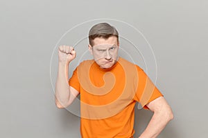 Portrait of funny disgruntled rebellious man raising clenched fist up