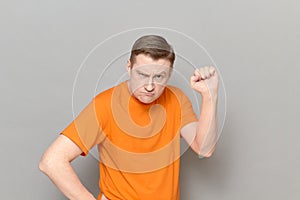 Portrait of funny disgruntled rebellious man raising clenched fist up
