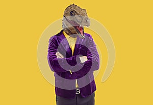 Portrait of funny extravagant man in dinosaur mask who confidently poses with folded hands.
