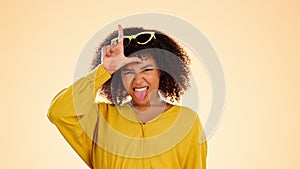 Portrait, funny face and loser with a black woman in studio on a yellow background making fun. Hand gesture, rude and