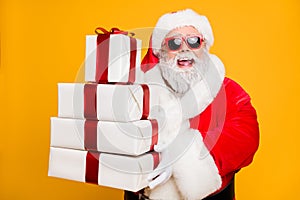 Portrait of funny funky grey hair santa claus in red hat hold packages he brings for good kids people celebrate newyear