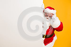 Portrait of funny funky santa claus in red headwear look behind white billboard wonder incredible 2020 christmas magic