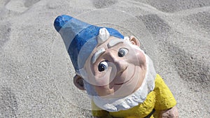 Portrait of a funny garden gnome in front of the beach