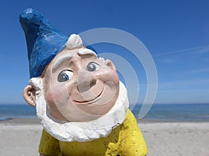 Portrait of a funny garden gnome in front of blue sky