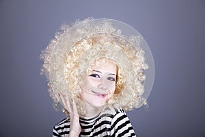 Portrait of funny girl in blonde wig.