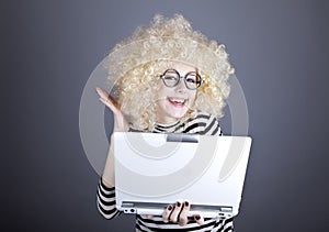 Portrait of funny girl in blonde wig with laptop.