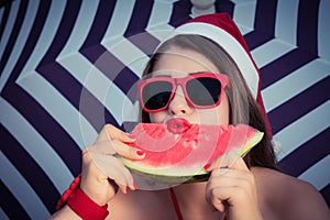 Portrait of a funny girl in Santa Claus hat and red sunglasses