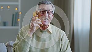 Portrait funny grandpa retired pretends to speak banana like on phone humorous conversation old man jokingly pretending