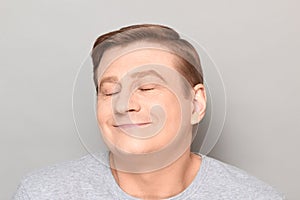 Portrait of funny happy man dreaming about something pleasant